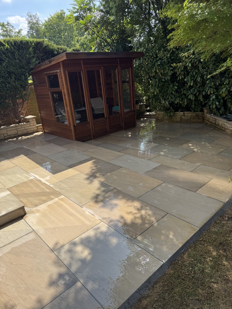 Completed garden patio with large-format paving and timber summer house